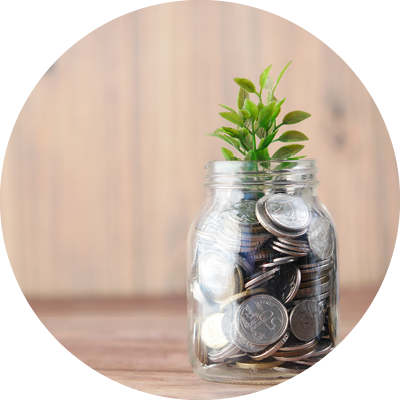 A jar of coins with a leaf on top, pictured at a table, representing profitability